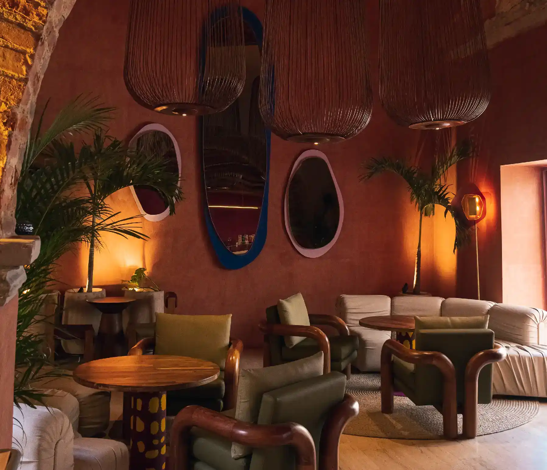 Cozy dining room at Nía Bakery with vintage furniture, artisan mirrors and tropical plants at Cartagena coffee shop