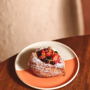 French croissant pastry with fresh strawberries and edible flowers at Nía Bakery artisan bakery Cartagena Colombia