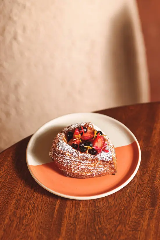 French croissant pastry with fresh strawberries and edible flowers at Nía Bakery artisan bakery Cartagena Colombia