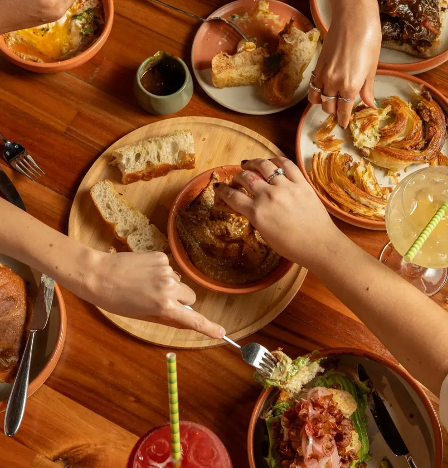 Friends sharing artisan pastries and cocktails at Nía Bakery coffee shop and restaurant in Cartagena Historic Center